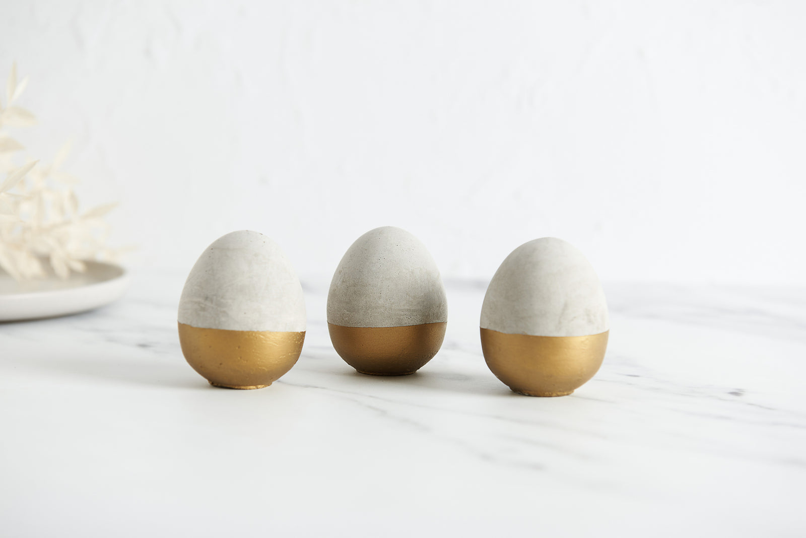 3 grey and gold concrete eggs