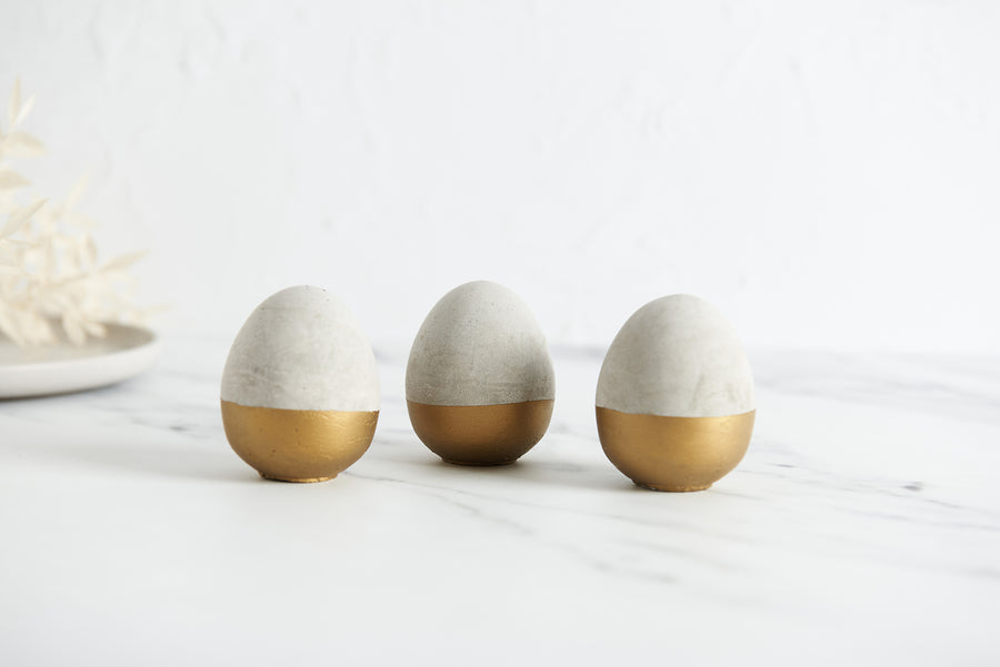 3 grey and gold concrete eggs